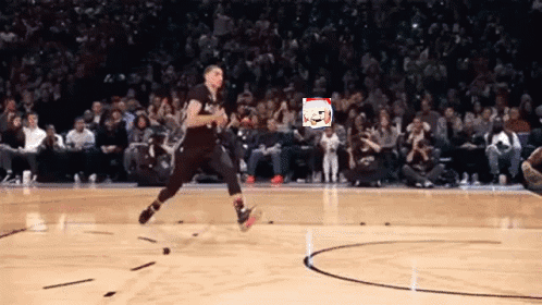 A Basketball Player Is Jumping In The Air On A Court With A Crowd Watching GIF