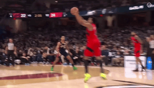 a basketball player is jumping in the air to catch a basketball
