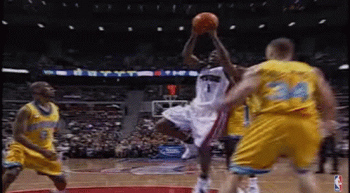 A Basketball Player Is Jumping In The Air To Catch A Basketball While Playing Basketball . GIF