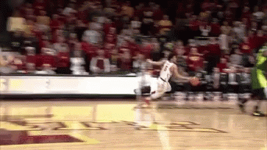 a basketball player is jumping in the air while dribbling the ball