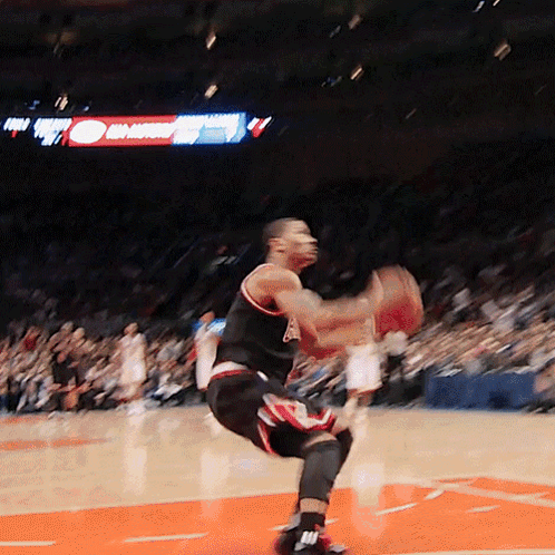 A Basketball Player Is Jumping In The Air While Holding A Ball GIF