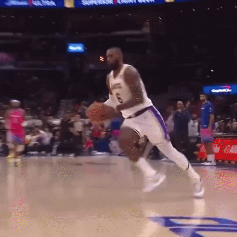 A Basketball Player Is Jumping In The Air While Holding A Basketball . GIF