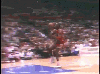 A Basketball Player Is Jumping In The Air While Holding A Basketball In His Hand . GIF