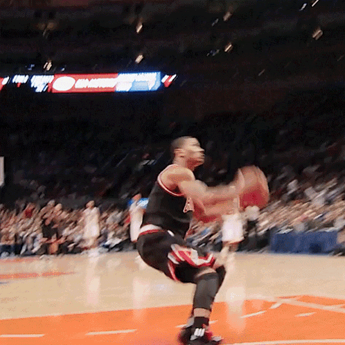 A Basketball Player Is Jumping In The Air While Holding A Basketball In His Hands GIF