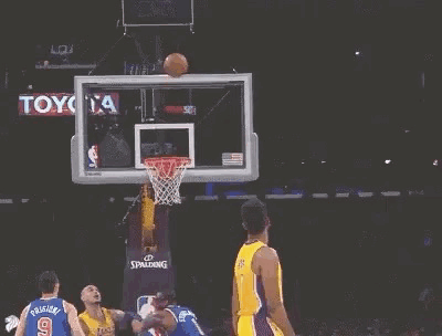 A Basketball Player Is Jumping In The Air With His Arms Outstretched . GIF