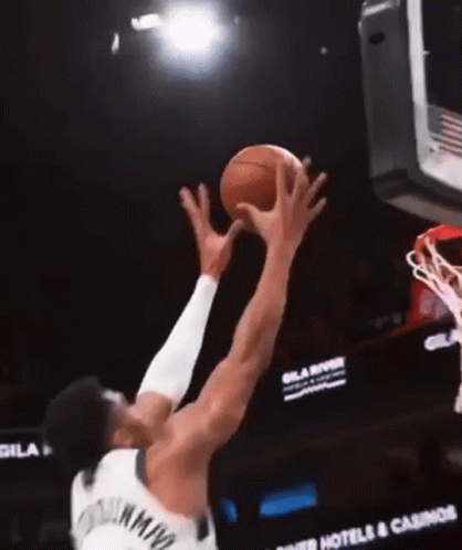 A Basketball Player Is Jumping To Catch A Basketball In The Air GIF