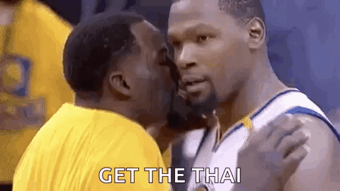 a basketball player is kissing another player on the cheek while another player says `` get the thai '' .