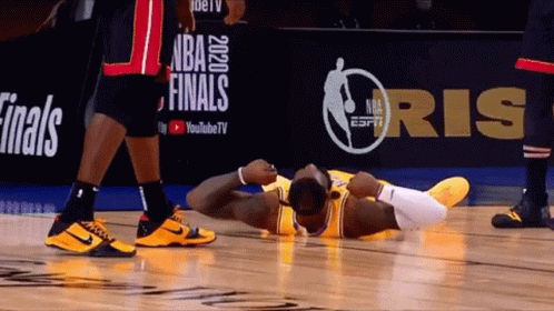 A Basketball Player Is Laying On The Floor In Front Of A Nba Finals Sign GIF