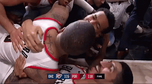 a basketball player is laying on the floor surrounded by fans during a game against okc