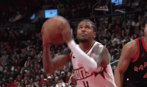 a basketball player is shooting a basketball in front of a crowd while wearing a number 4 jersey .