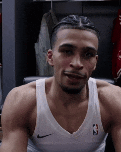 A Basketball Player Is Sitting In A Chair In A Locker Room Wearing A White Nike Tank Top . GIF