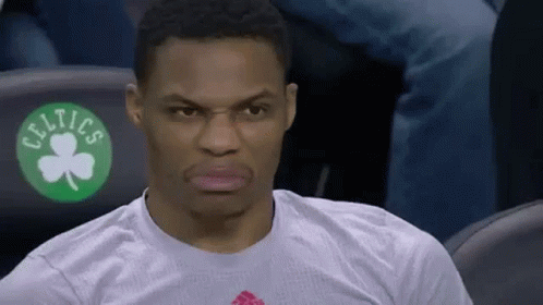 A Basketball Player Is Sitting In The Stands Wearing A White Shirt With A Green Shamrock On It . GIF