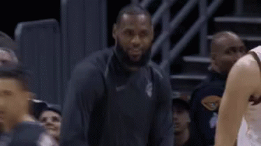 A Basketball Player Is Sitting On The Bench During A Game While Another Player Looks On . GIF