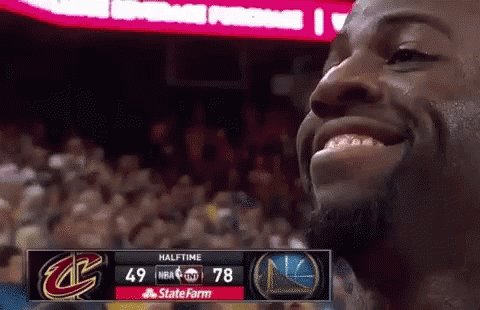 A Basketball Player Is Smiling In Front Of A Scoreboard That Says Halftime On It GIF