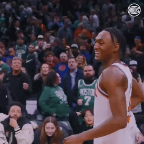 A Basketball Player Is Smiling While Standing In Front Of A Crowd At A Basketball Game . GIF