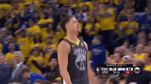 A Basketball Player Is Standing In Front Of A Crowd Of People . GIF