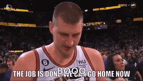 A Basketball Player Is Standing In Front Of A Crowd With A Woman Watching . GIF