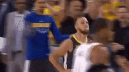 A Basketball Player Is Standing In The Middle Of A Crowd . GIF