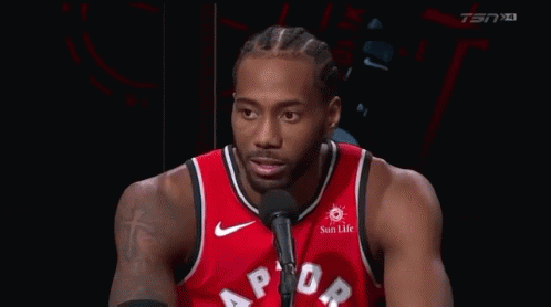 A Basketball Player Is Talking Into A Microphone While Wearing A Red Raptors Jersey . GIF