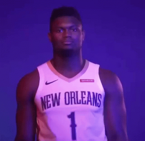 A Basketball Player Is Wearing A New Orleans Jersey And Standing In Front Of A Purple Background . GIF