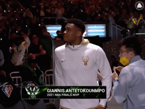 A Basketball Player Named Giannis Antetokounmpo Is Standing In The Stands GIF
