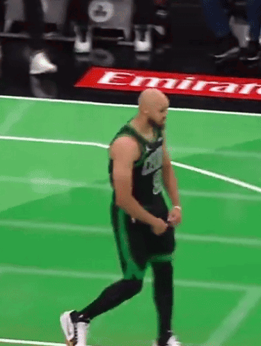 A Basketball Player On A Green Court With An Emirates Ad In The Background GIF