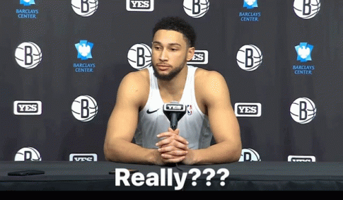 A Basketball Player Sitting At A Table With A Microphone In Front Of A Wall That Says Yes GIF