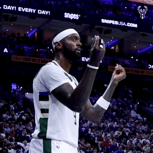 A Basketball Player Stands In Front Of A Snipes Sign GIF