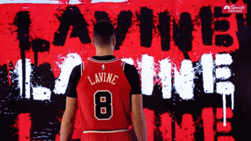 A Basketball Player Stands In Front Of A Wall That Says Lavine 8 GIF