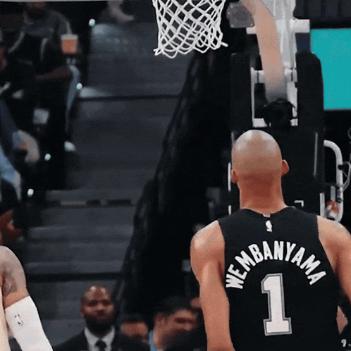 A Basketball Player Wearing A Black Jersey With The Number 1 On It GIF