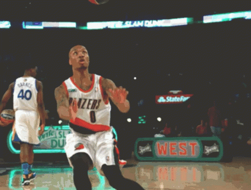 a basketball player wearing a blazers jersey throws the ball