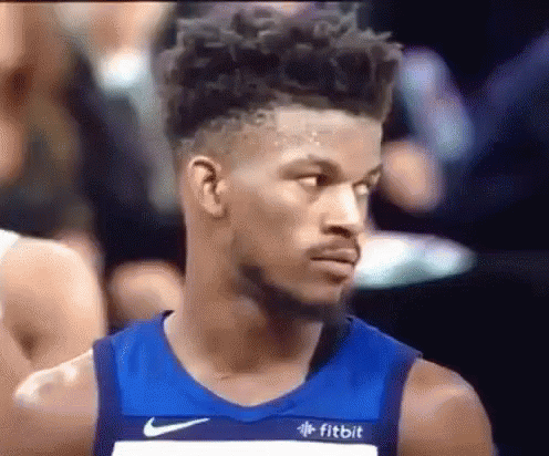A Basketball Player Wearing A Blue Nike Jersey Is Looking At Something . GIF
