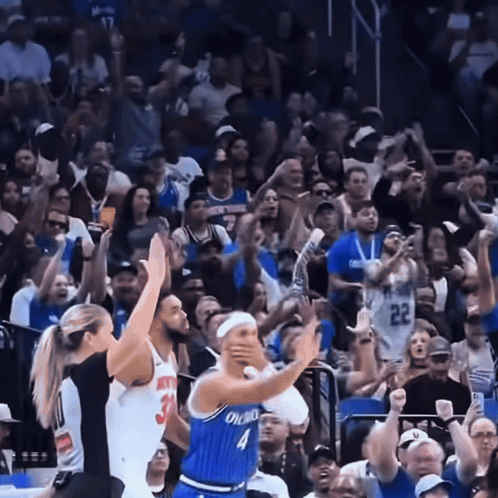 A Basketball Player Wearing A Blue Orlando Jersey Stands In Front Of A Crowd GIF