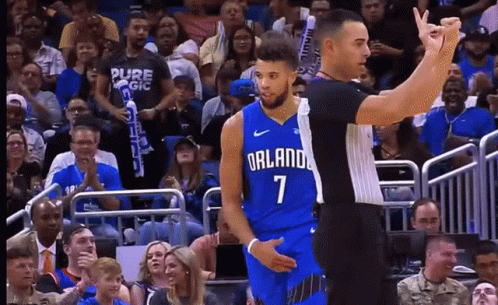A Basketball Player Wearing A Blue Orlando Jersey Stands Next To A Referee GIF