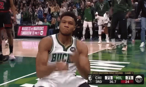 A Basketball Player Wearing A Buck Jersey Is Kneeling Down On The Court GIF