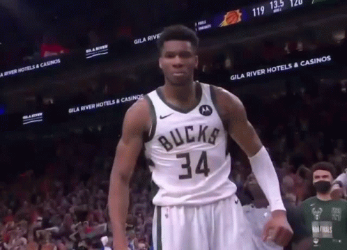 A Basketball Player Wearing A Bucks 34 Jersey Stands In Front Of A Crowd GIF