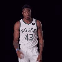 A Basketball Player Wearing A Bucks Jersey Holds His Hands To His Head GIF
