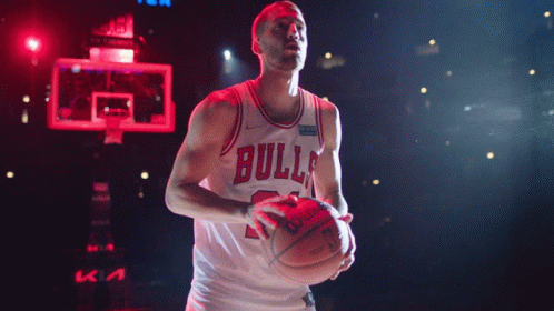 A Basketball Player Wearing A Bulls Jersey Is Holding A Basketball GIF