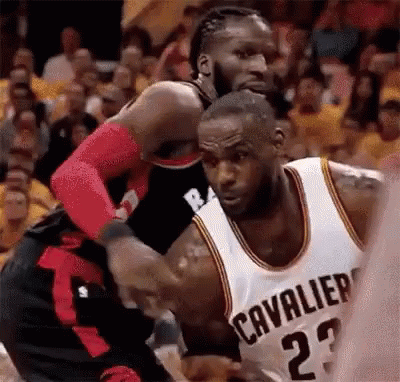 A Basketball Player Wearing A Cleveland Cavaliers Jersey Is Fighting Another Player . GIF