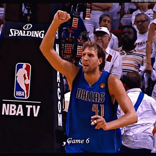A Basketball Player Wearing A Dallas Jersey Holds Up His Fist In The Air GIF