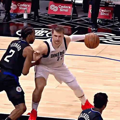A Basketball Player Wearing A Dallas Jersey Is Dribbling The Ball GIF