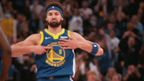 A Basketball Player Wearing A Golden State Warriors Jersey Is Pointing To His Chest . GIF