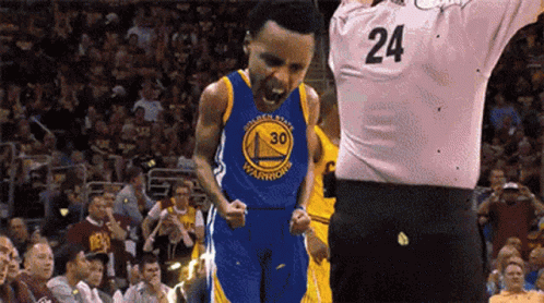 A Basketball Player Wearing A Golden State Warriors Jersey Is Standing In Front Of A Referee With His Mouth Open . GIF