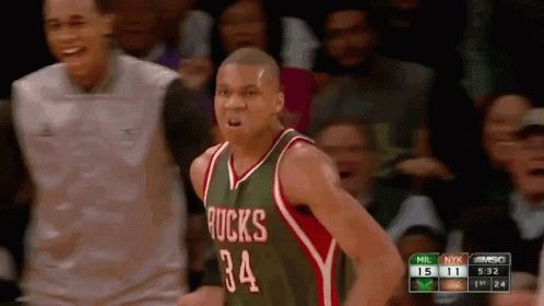 A Basketball Player Wearing A Green And Red Jersey With The Number 34 GIF