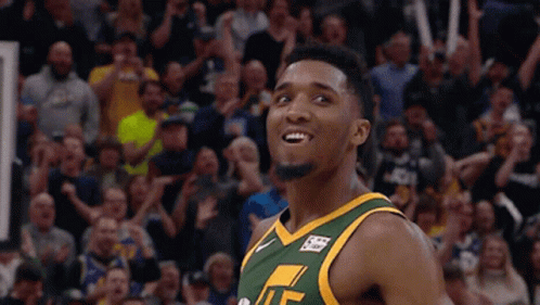 A Basketball Player Wearing A Green And Yellow Jersey With The Letter T On It GIF