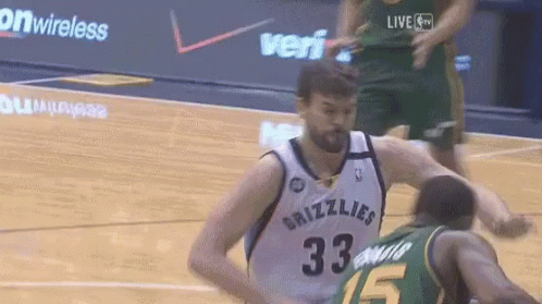 A Basketball Player Wearing A Grizzlies Jersey Is Being Fouled By Another Player GIF