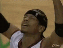 A Basketball Player Wearing A Headband Is Raising His Arms In The Air . GIF