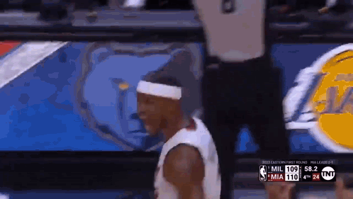 A Basketball Player Wearing A Headband Is Walking On The Court During A Game . GIF
