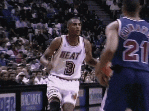 A Basketball Player Wearing A Heat Jersey Runs Towards Another Player Wearing A Number 21 Jersey GIF