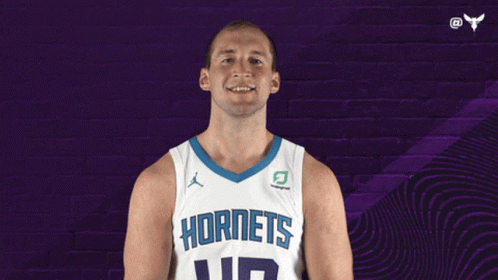 A Basketball Player Wearing A Hornets Jersey Is Smiling GIF